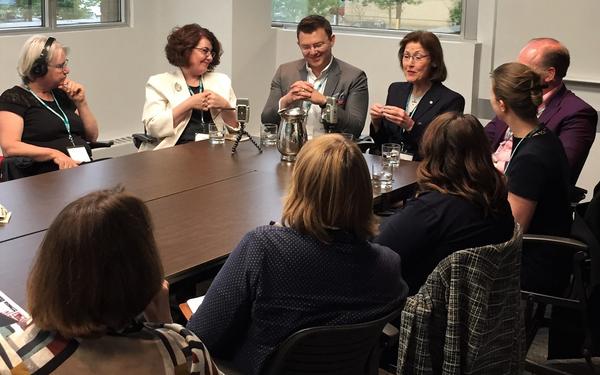 High quality candid photo of a small diverse group of corporate employees having an animated discussion during a training session break.