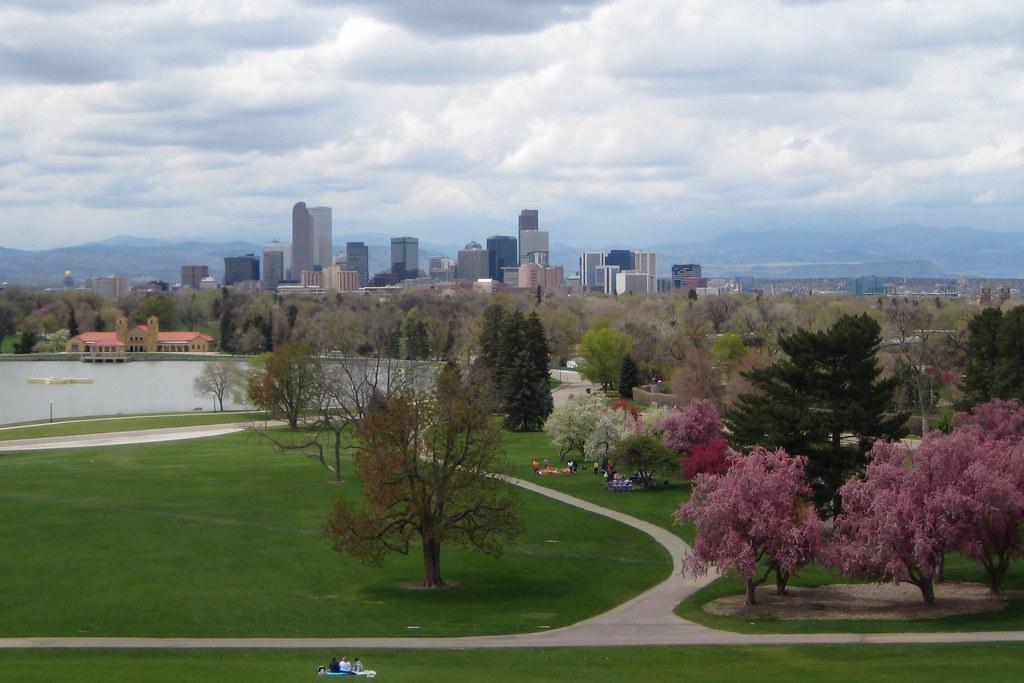 View of Denver skyline and Rocky Mountains from City Park, with Ferril Lake in the foreground