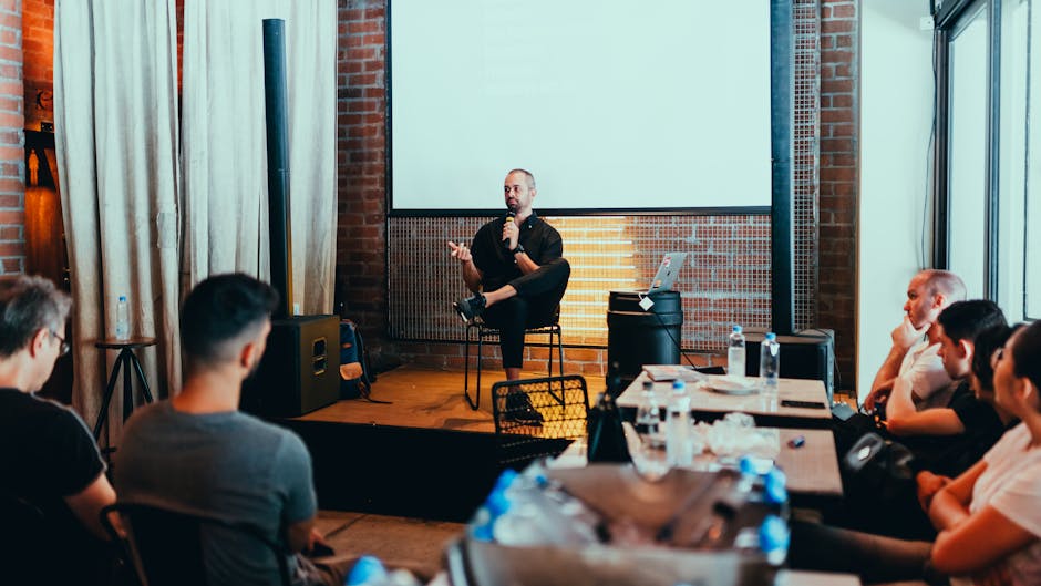 A speaker at a corporate event podium with the company logo prominently displayed.