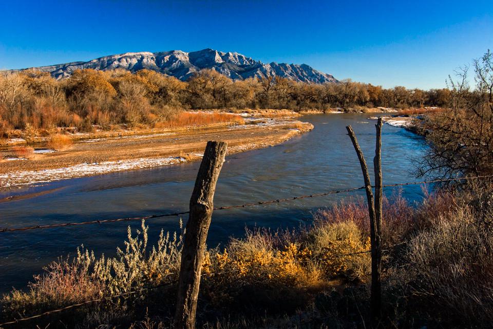 A scenic view of the Corrales bosque with the Rio Grande river and Sandia mountains in the background