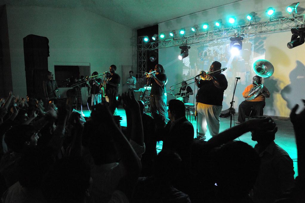 Brass band performing at the French Quarter Festival with dramatic lighting