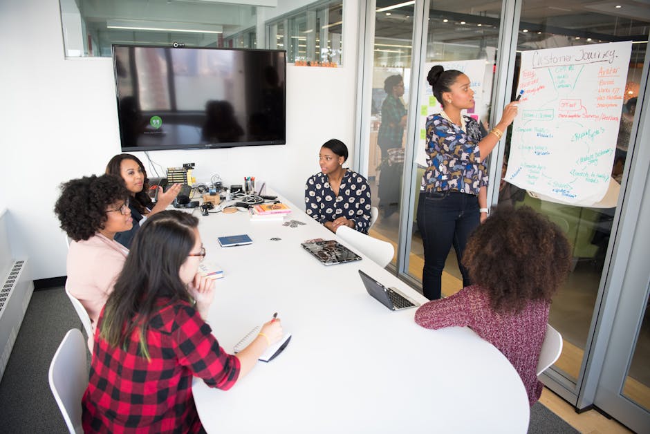 Event planners discussing details in a meeting room with a vision board visible