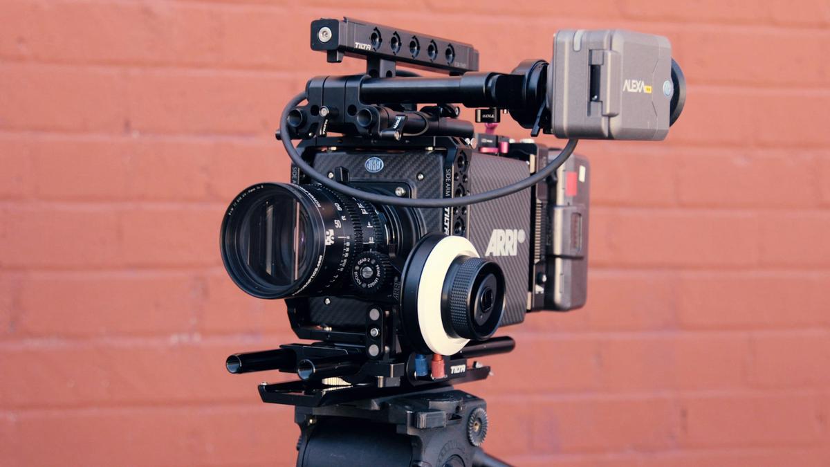 Display of high-end camera equipment including ARRI Alexa Mini and RED Monstro cameras with various lenses and accessories