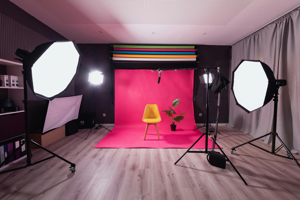 A well-organized home photography studio setup with natural lighting, DIY backdrops, and creative use of space