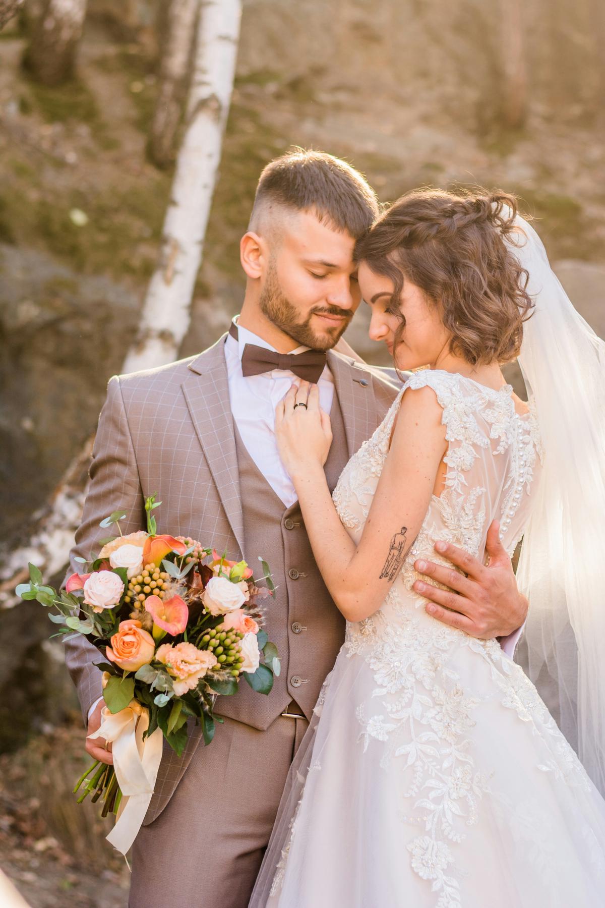 A bride and groom standing in an embrace during golden hour in Miami with warm, soft lighting highlighting their faces
