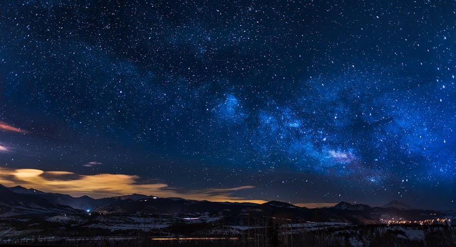 A breathtaking night sky filled with stars and the Milky Way galaxy stretching across the frame, with the silhouette of a desert landscape, such as rock formations or cacti, in the foreground.
