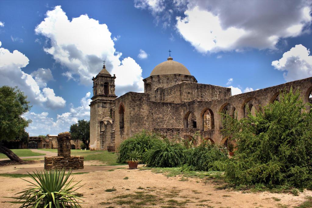 The grand exterior of Mission San Jos&eacute;, featuring the iconic carved rose window and imposing stone architecture.