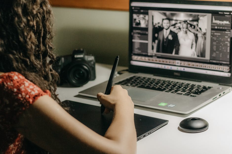 A photographer editing photos on a laptop while following an online photography course.