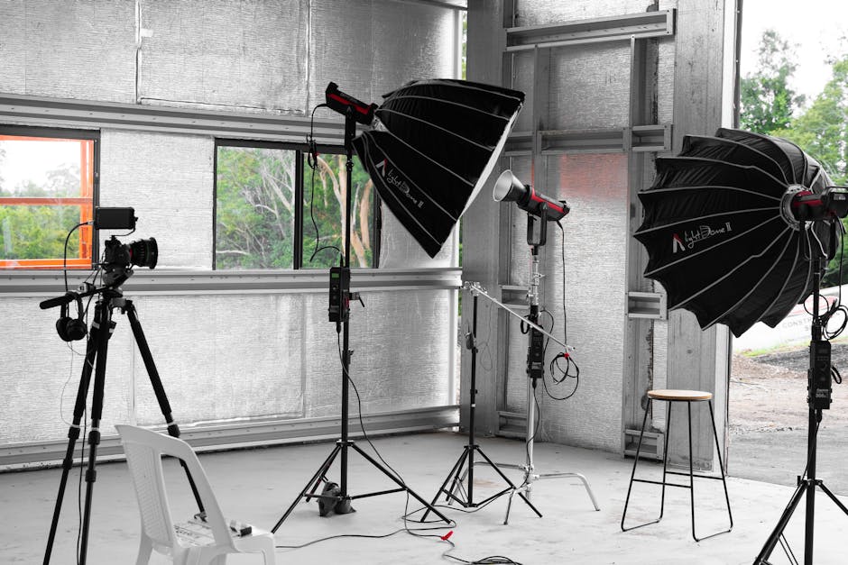 A modern, well-equipped photography studio with natural light, various backdrops, and professional lighting equipment