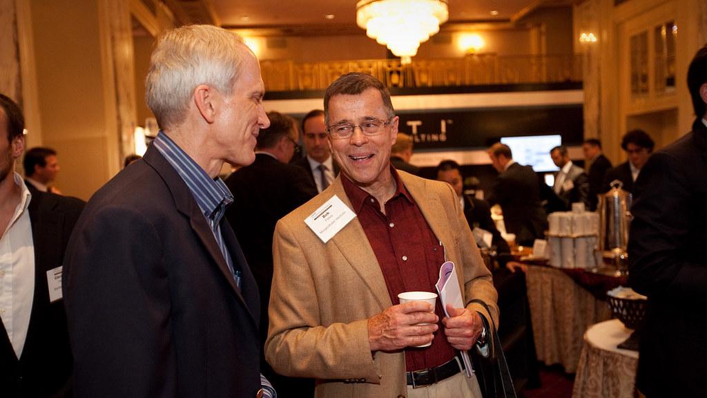 A professional photographer capturing moments at a corporate event, focusing on attendees networking and engaging in discussions