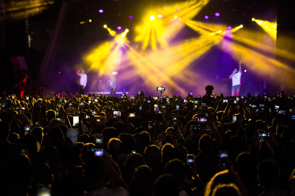 A concert photographer capturing the energy of a cheering crowd