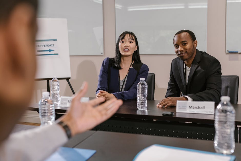 A corporate event photographer discussing event details with clients in a modern office setting