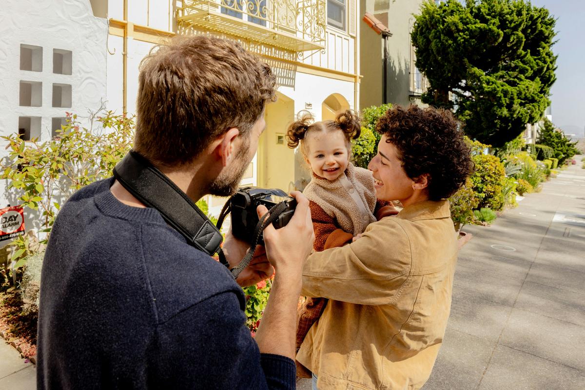 A photographer engaging with a family during a photo session