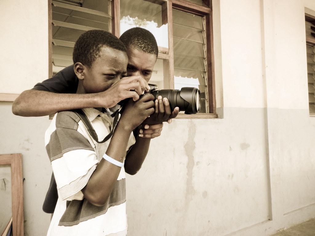 An instructor giving a one-on-one photography lesson outdoors
