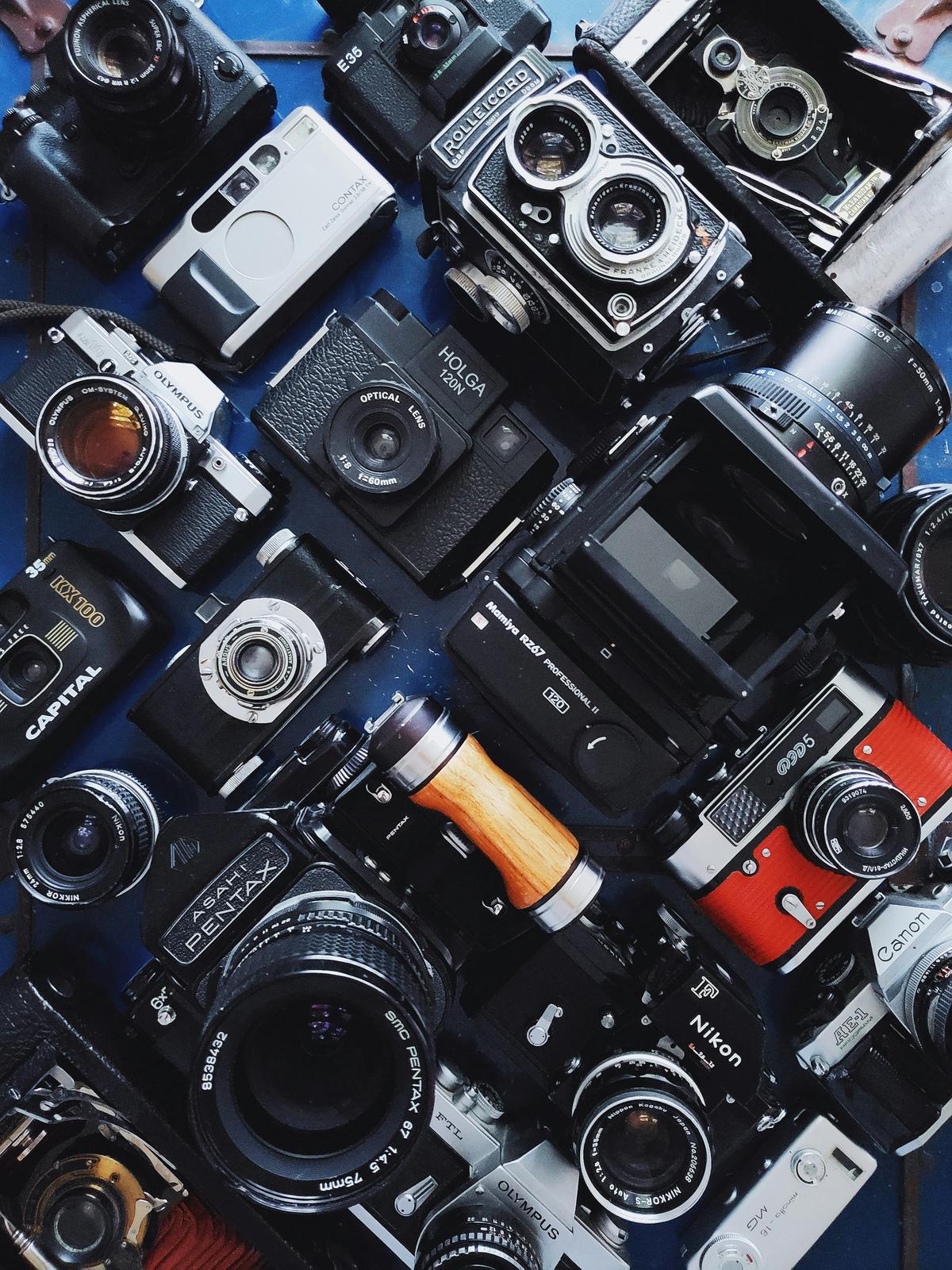 A collection of high-end professional photography equipment, including cameras, lenses, and lighting gear.