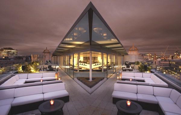 A rooftop bar scene at Roxy's Pub with patrons enjoying drinks and city views