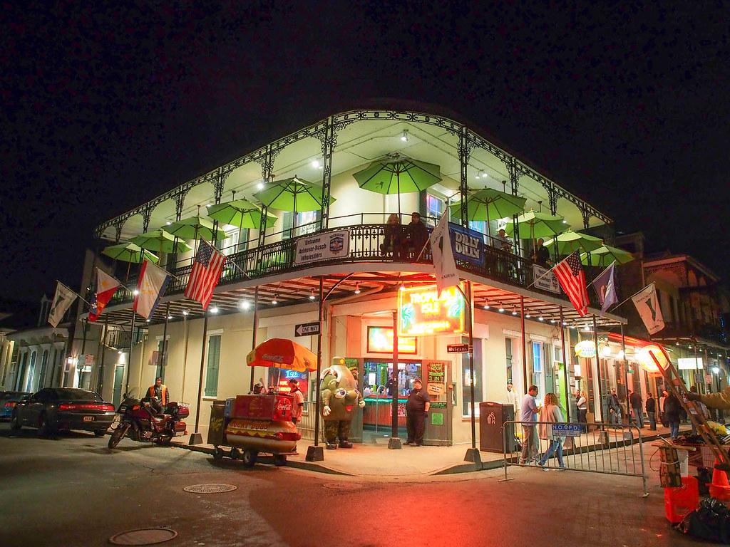 A collage of five iconic New Orleans locations illuminated at night: Bourbon Street, Jackson Square, City Park, Faubourg Marigny, and Audubon Park