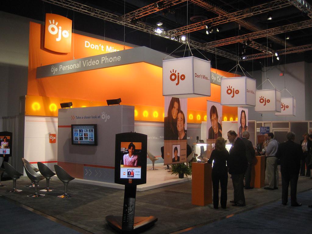 A professionally photographed trade show booth with engaging product displays and attendees interacting with brand representatives